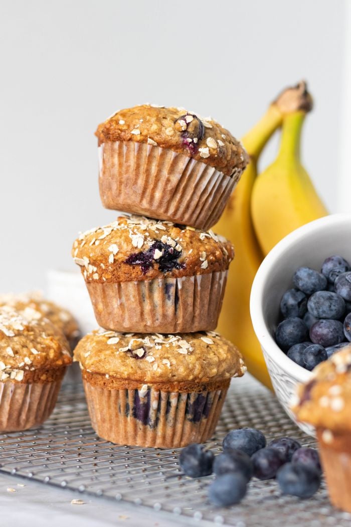 a side view of three banana blueberry oatmeal muffins stacked